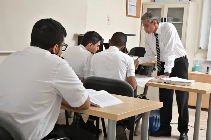 An instructor helping trainees at their desks