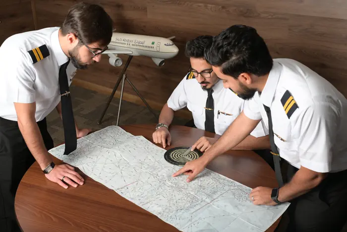 Trainees plotting a route on a navigation chart